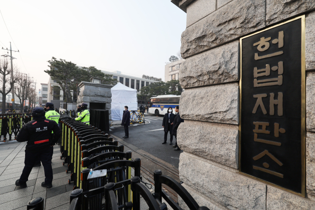 윤석열 대통령의 탄핵심판 3차 변론이 열리는 21일 서울 종로구 헌법재판소 앞에 경찰들이 출입을 통제하며 경계 근무를 강화하고 있다. 연합뉴스