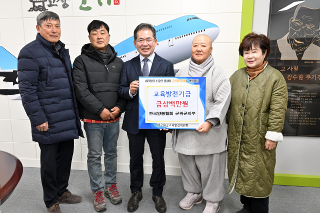 한국양봉협회 군위군지부가 군위군에 교육발전기금을 기탁하고, 김진열 군수와 기념 사진을 촬영하고 있다. 군위군 제공