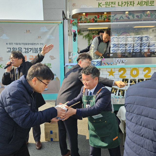 한수원 박천중 상생협력처장(오른쪽)이 협력기업인 (주)터보링크 직원에게 먹거리를 전달하고 있다. 한수원 제공