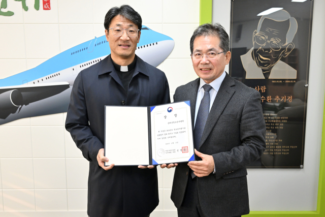 박동찬(왼쪽) 대구 군위군청소년수련원 원장이 여성가족부장관 표창을 받고,김진열(오른쪽) 군수와 기념 사진을 촬영하고 있다. 군위군 제공