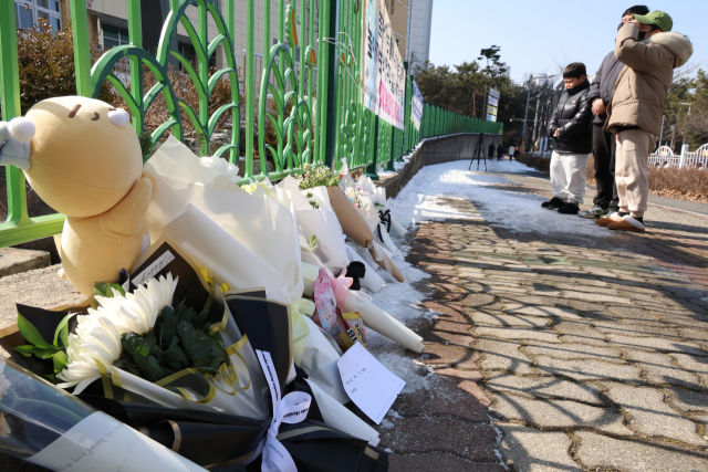 11일 오전, 초등생 1학년 여아가 살해당한 대전 서구 한 초등학교에서 학부모가 어린 자녀와 함께 사망한 김하늘 양을 위해 추모를 하고 있다. 연합뉴스