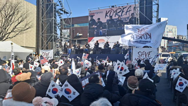 11일 충남 천안시 천안종합터미널앞 광장에서 열린 윤석열 대통령 탄핵 반대 집회에서 참석자들이 태극기와 성조기를 흔들고 있다. 연합뉴스