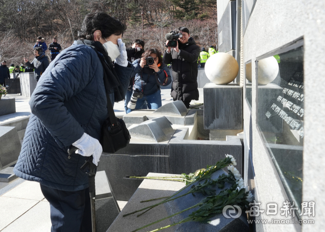 대구지하철참사 22주기 추모식이 18일 대구시민안전테마파크에서 열린 가운데 유가족들이 32명의 희생자 유해가 묻힌 잔디밭에서 고인을 추모하고 있다. 안성완 기자 asw0727@imaeil.com