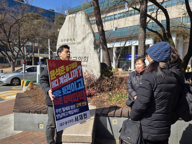 서재헌 더불어민주당 전 동구청장 후보가 급여 반납을 촉구하는 1인 시위를 하며 구민들에게 시위 취지를 설명하고 있다. 김유진 기자