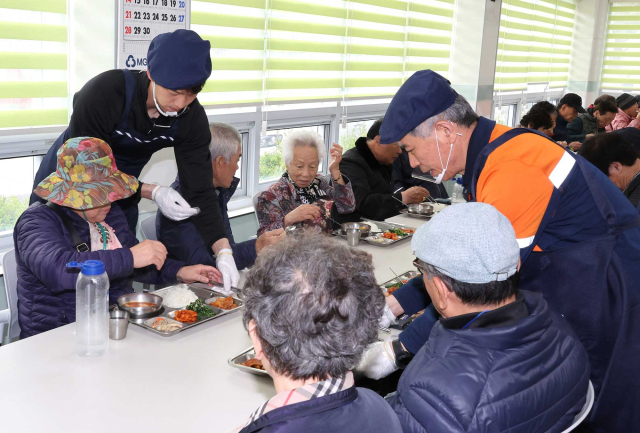 포항스틸러스 황인재 선수와 포항제철소 STS제강부 직원이 함께 어르신들에게 식사를 대접하고 있다. 포스코 제공