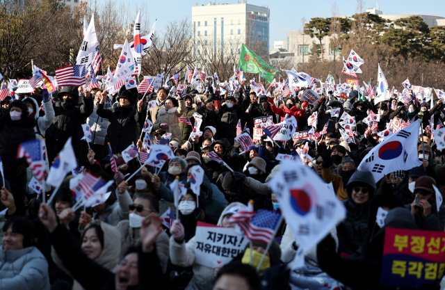 22일 대전시청 앞 보라매공원에서 세이브코리아가 주최한 국가비상기도회에서 참석자들이 윤석열 탄핵 반대를 외치며 태극기를 흔들고 있다. 김영진 기자 kyjmaeil@imaeil.com