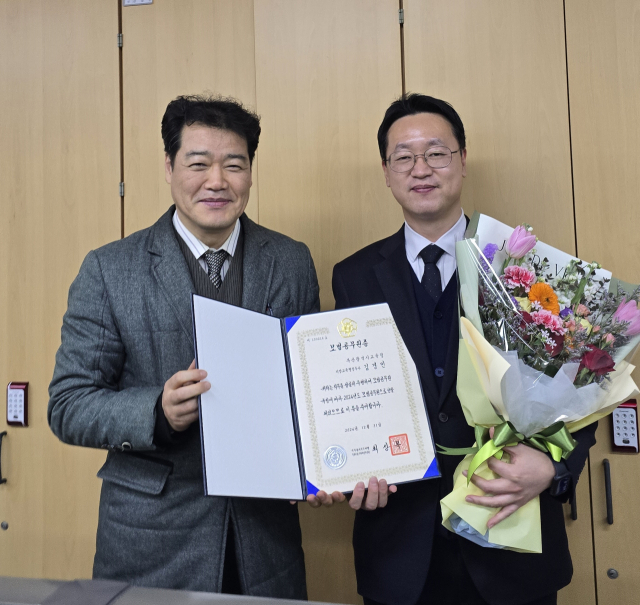 부산시교육청 소속 김경민 주무관(오른쪽)이 모범공무원증을 받고 있다. [사진=부산교육청]