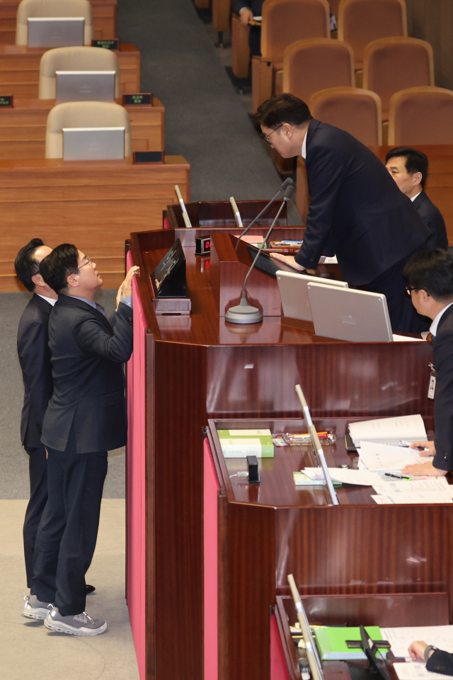 더불어민주당 박찬대 원내대표와 박성준 원내수석부대표가 27일 국회 본회의에서 의장석을 찾아가 상법 개정안을 상정하지 않겠다고 밝힌 우원식 국회의장과 대화하고 있다. 연합뉴스