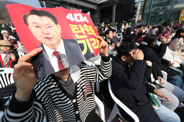 9일 서울 용산구 한남동 대통령 관저 인근에서 열린 사랑제일교회 연합 예배에서 한 참가자가 탄핵 기각을 촉구하는 손팻말을 들고 있다. 연합뉴스