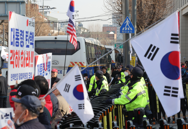 윤석열 대통령에 대한 탄핵심판 선고를 앞두고 11일 서울 종로구 헌법재판소 앞에서 시위자들이 탄핵 반대를 촉구하고 있다. 연합뉴스