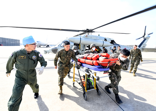 12일 포항 동방 해상에서 자유의 방패(Freedom Shield) 연습의 일환으로 진행된 전시 해상 전상자 탐색구조 및 합동의무지원 훈련에서 이국종 국군대전병원장(왼쪽)을 비롯한 한미 구조·의무대원들이 해상 구조 전상자를 해군항공사령부 주기장에 마련된 임시 응급처치실로 이송하고 있다. 해군항공사령부 제공.