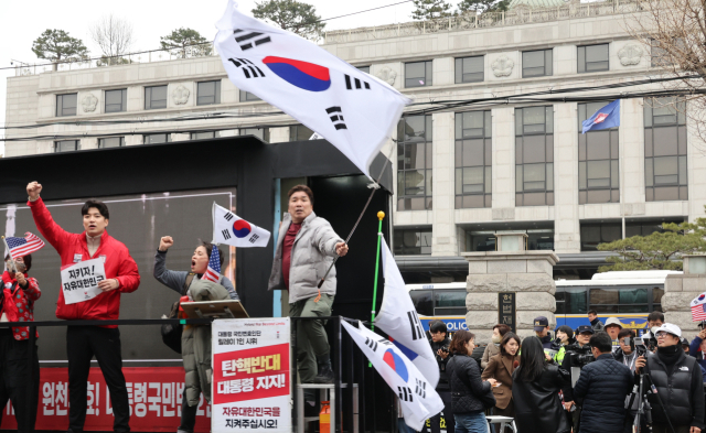 12일 윤석열 대통령 탄핵심판 선고를 앞두고 서울 종로구 헌법재판소 앞에서 보수단체 회원들이 탄핵 각하를 요구하고 있다. 연합뉴스