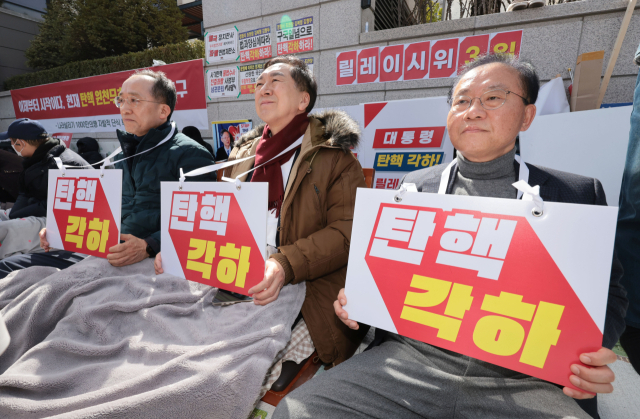 국민의힘 추경호(왼쪽부터), 김기현, 윤재옥 의원이 13일 서울 종로구 헌법재판소 앞에서 윤석열 대통령 탄핵 각하 촉구 릴레이 시위를 하고 있다. 연합뉴스