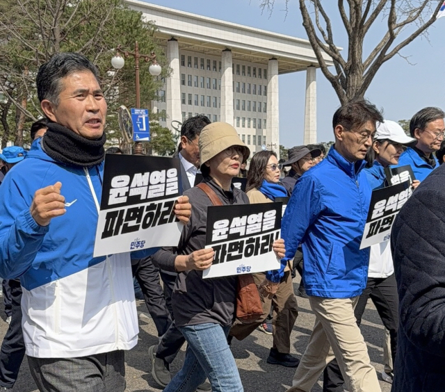 더불어민주당 의원들이 15일 국회에서 광화문으로 윤석열 대통령 파면 촉구 도보 행진을 하고 있다.