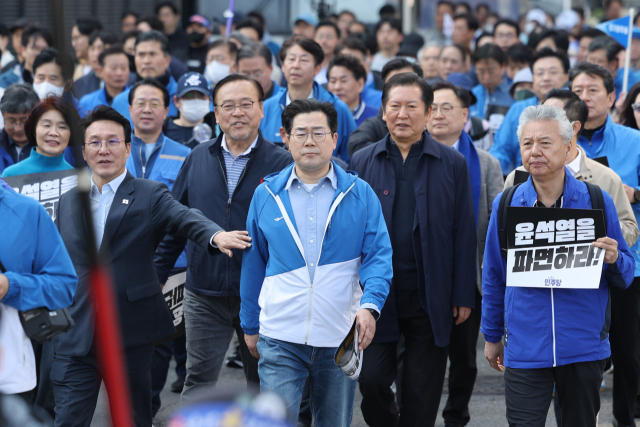 더불어민주당 박찬대 원내대표 및 의원들이 15일 국회에서 윤석열 대통령 파면 촉구 도보 행진을 시작해 광화문광장 인근에 도착하고 있다. 연합뉴스