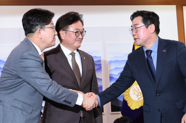 우원식 국회의장과 국민의힘 권성동 원내대표(왼쪽), 더불어민주당 박찬대 원내대표(오른쪽)가 20일 서울 여의도 국회의장실에서 국민연금 개혁안에 합의한 뒤 악수하고 있다. 연합뉴스