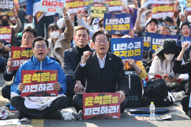 이재명 더불어민주당 대표와 박찬대 원내대표가 22일 서울 종로구 동십자각 앞에서 열린 야5당 공동 비상시국 범국민대회에서 구호를 외치고 있다. 연합뉴스