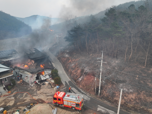 22일 경북 의성군 안평면 괴산리에서 발생한 산불이 급격하게 확산하는 가운데 한 주택 건물이 산불이 옮겨붙어 소실돼 있다. 연합뉴스