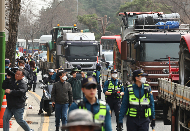 25일 전국농민회총연맹(전농) 회원들이 서울 서초구 남태령고개 일대에서 윤석열 대통령 탄핵을 촉구하는 집회를 가진 가운데 트랙터를 실은 트럭들이 세워져 있다. 전농은 이날 집회를 마친 뒤 광화문 방면으로 트랙터 행진할 계획이었으나 법원의 결정으로 불허됐다. 연합뉴스